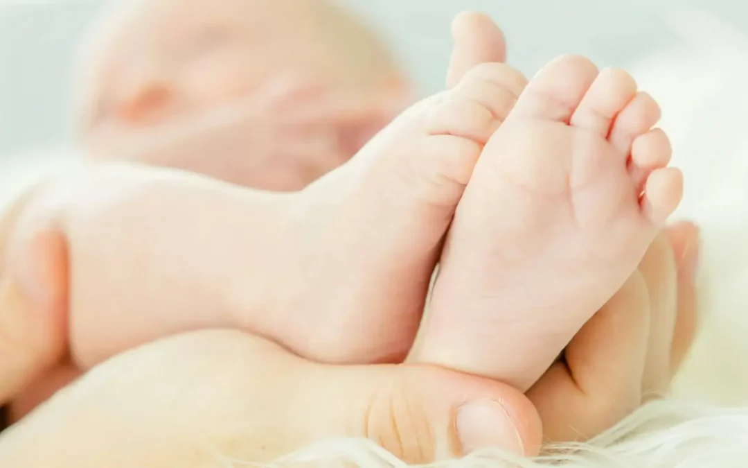 babies feet in new mothers hands